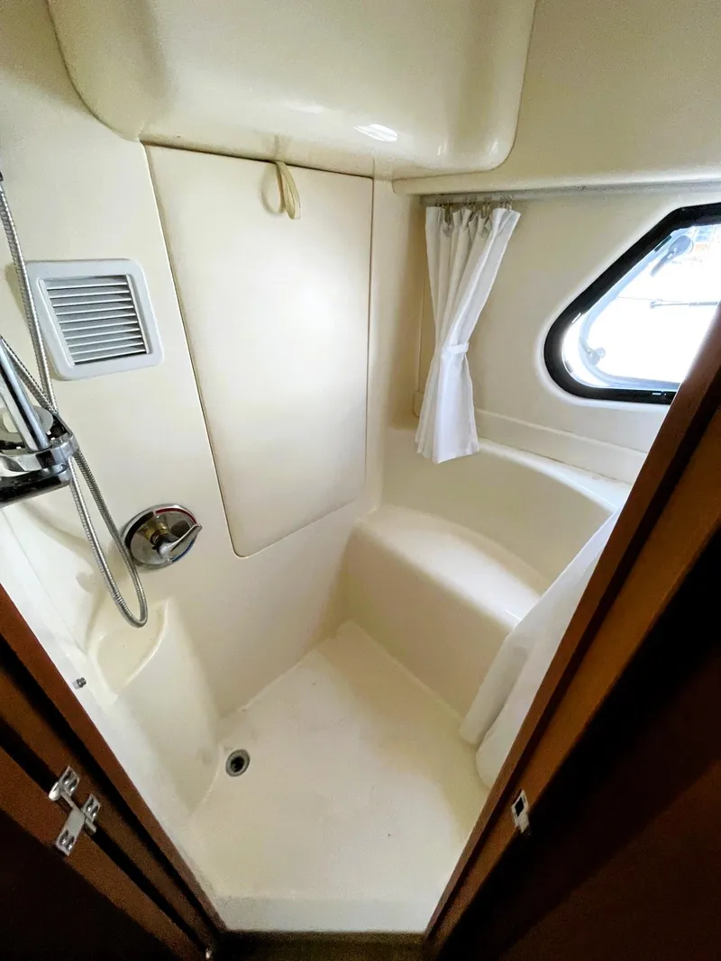 Slide: The Image of 2006 Silverton 39 Motor Yacht bathroom with shower, window, and curtain. - 34