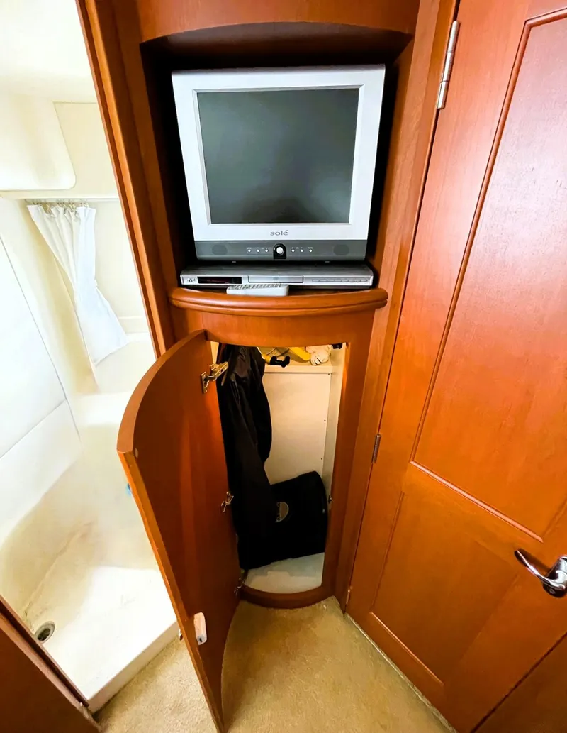 Slide: The Image of 2006 Silverton 39 Motor Yacht interior with TV and storage cabinet. - 37