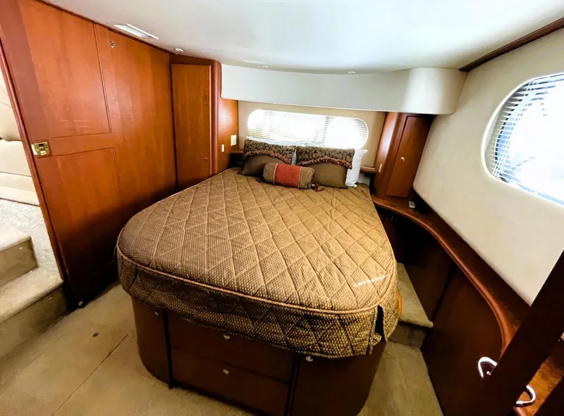 Slide: The Image of 2006 Silverton 39 Motor Yacht bedroom with cozy bed and wooden cabinetry. - 38