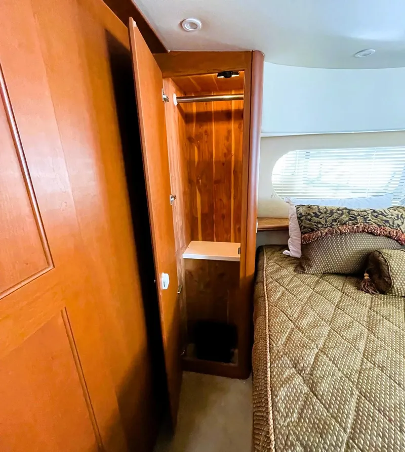 Slide: The Image of 2006 Silverton 39 Motor Yacht interior with wooden closet and cozy bed. - 39