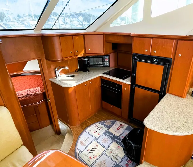 Slide: The Image of 2006 Silverton 39 Motor Yacht interior kitchen with wood cabinetry, appliances, and a cozy design. - 41
