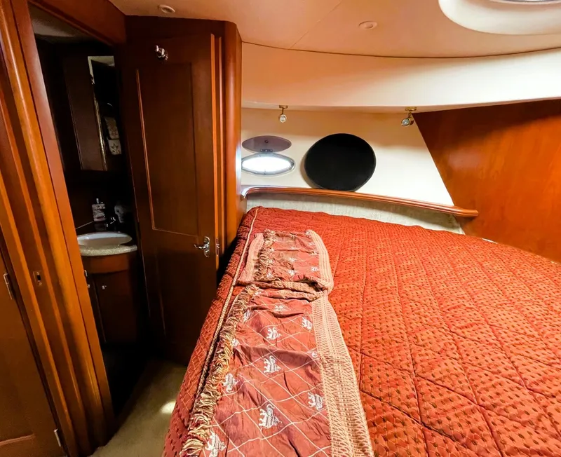 Slide: The Image of Luxurious 2006 Silverton 39 Motor Yacht bedroom with elegant red bedding and ensuite bathroom. - 43
