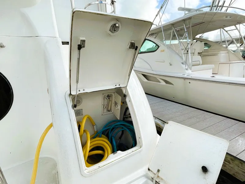 Slide: The Image of 2006 Silverton 39 Motor Yacht with open storage compartment and docked boats. - 7