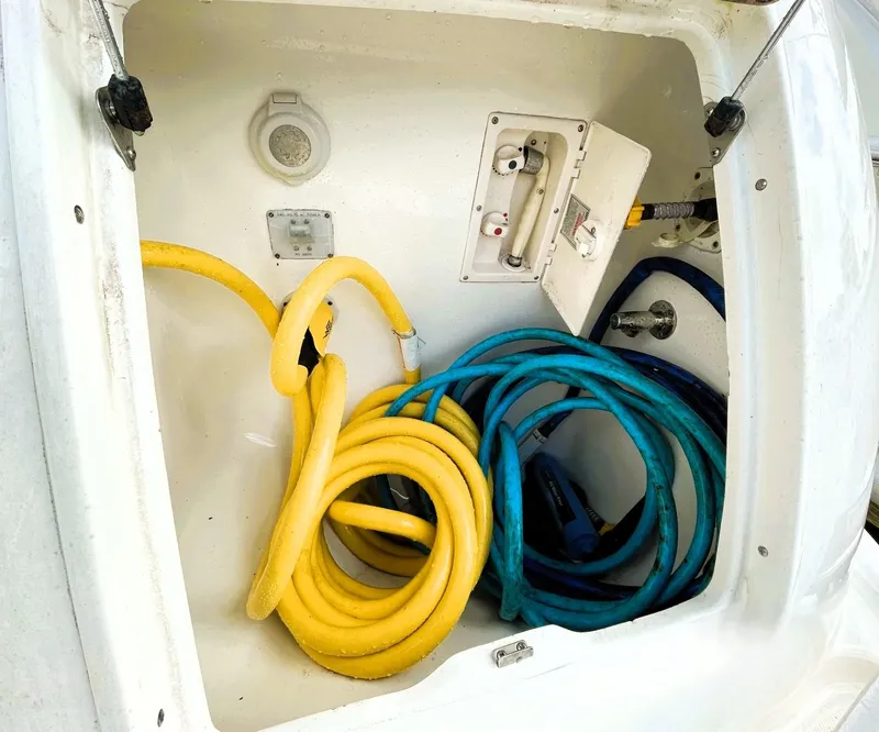 Slide: The Image of Storage compartment of 2006 Silverton 39 Motor Yacht with yellow and blue hoses. - 9