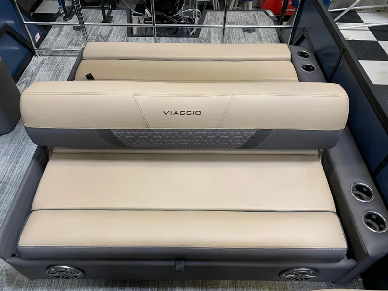 Slide: The Image of 2025 Viaggio Lago Z 24 S boat seating with beige and gray upholstery, cup holders, and speakers. - 6