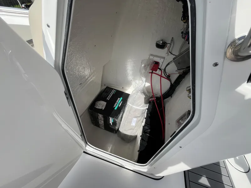 Slide: The Image of 2025 Key West 189 FS boat storage compartment with battery and wiring. - 12
