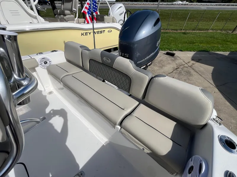 Slide: The Image of 2025 Key West 189 FS boat with cushioned seating and outboard motor. - 5