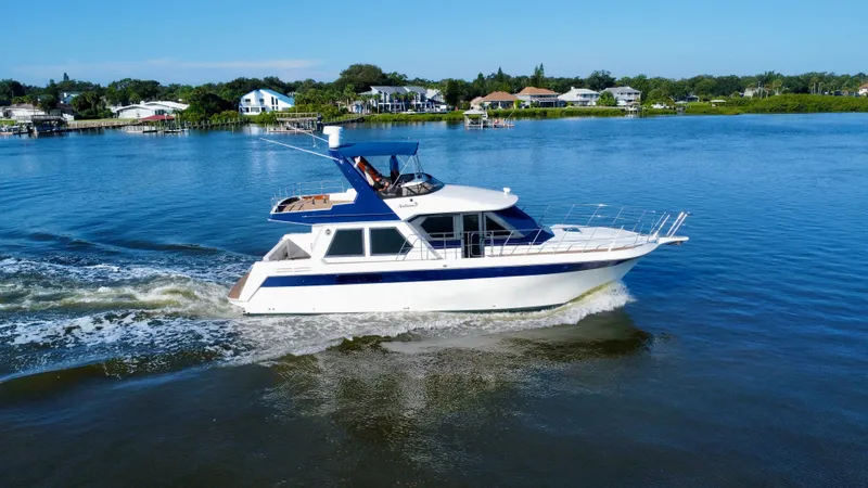 Slide: The Image of 1998 Navigator Pilothouse yacht cruising on a serene lake. - 13