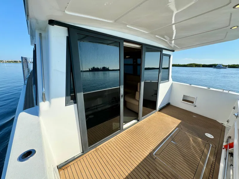 Slide: The Image of 1998 Navigator Pilothouse yacht with spacious deck and sliding glass doors on calm water. - 17