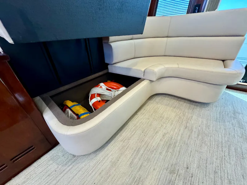 Slide: The Image of 1998 Navigator Pilothouse interior with storage under beige seating, containing life jackets. - 21