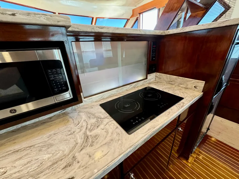 Slide: The Image of Navigator Pilothouse 1998 kitchen with marble countertop, induction cooktop, and microwave. - 27