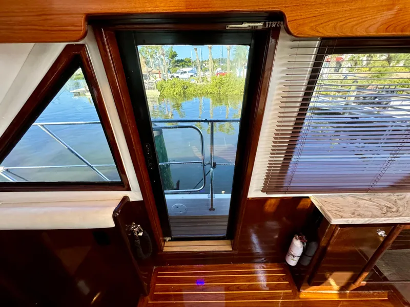 Slide: The Image of Interior view of 1998 Navigator Pilothouse yacht with wooden finishes and glass door. - 40