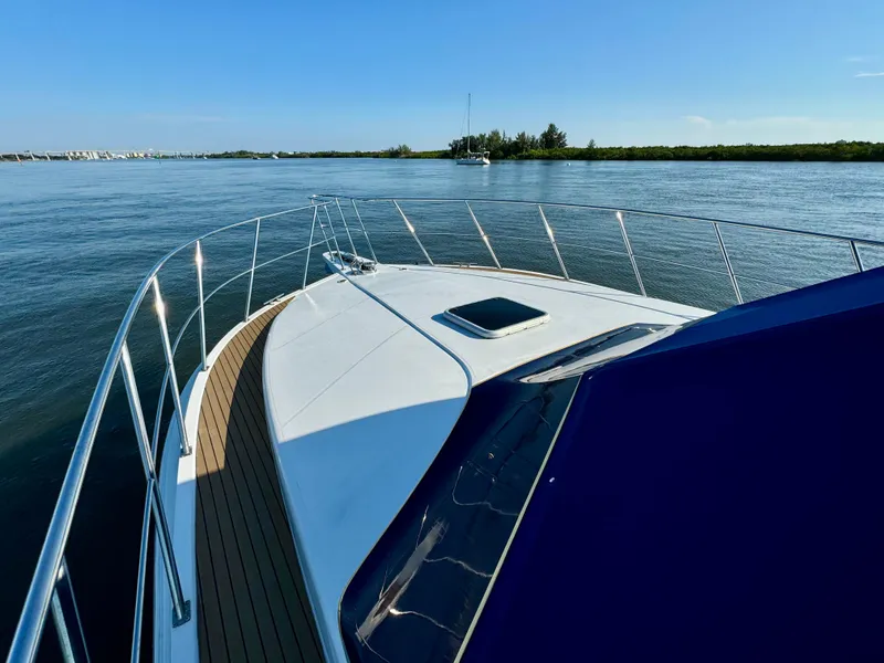 Slide: The Image of 1998 Navigator Pilothouse yacht on calm water, clear sky, and scenic shoreline. - 42
