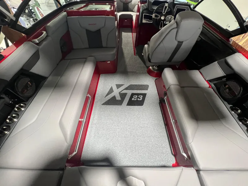 Slide: The Image of 2024 MasterCraft XT23 boat interior with gray seating and red accents. - 6