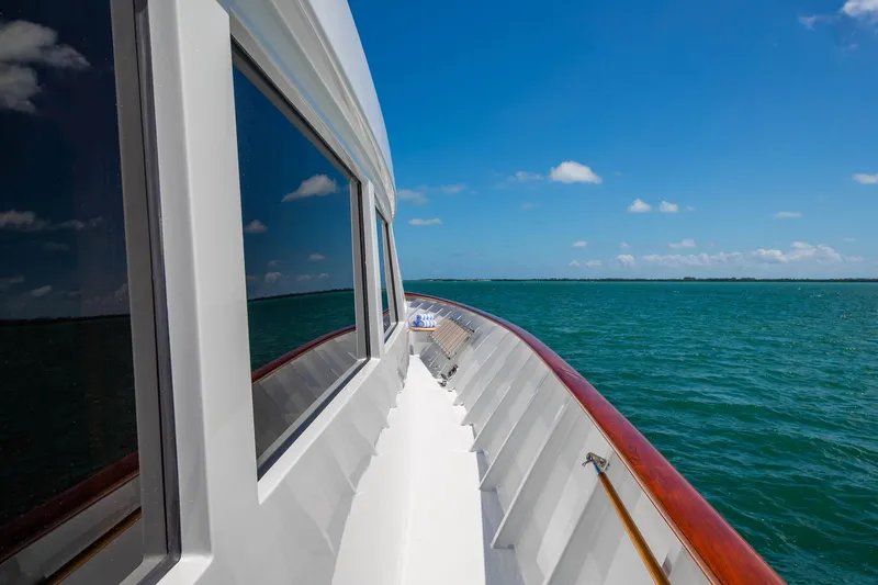 Slide: The Image of Side view of 1998 Burger Raised Pilothouse yacht on open sea under clear blue sky. - 11