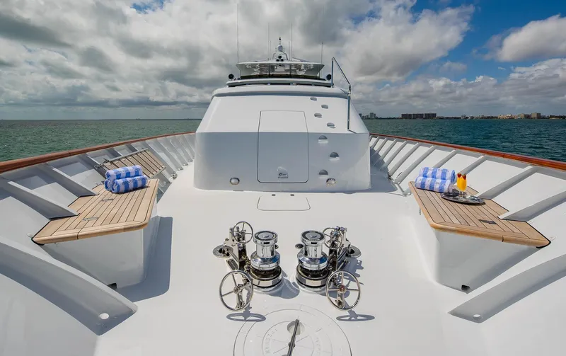 Slide: The Image of 1998 Burger Raised Pilothouse yacht deck with winches and seating, under a partly cloudy sky. - 12