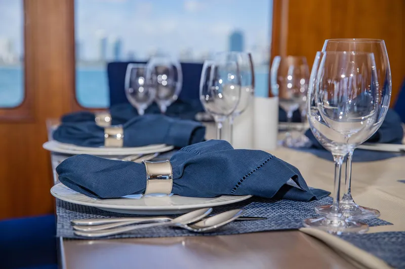 Slide: The Image of Elegant dining setup on 1998 Burger Raised Pilothouse yacht with blue napkins and glassware. - 34