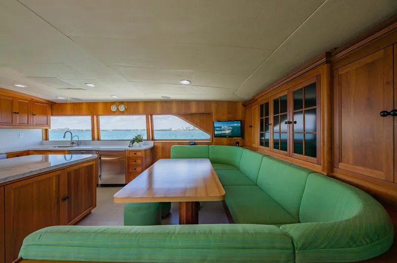 Slide: The Image of Luxurious 1998 Burger Raised Pilothouse yacht interior with green seating and wooden cabinetry. - 35