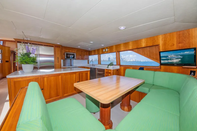 Slide: The Image of Luxurious 1998 Burger Raised Pilothouse yacht interior with green seating and wooden dining area. - 36