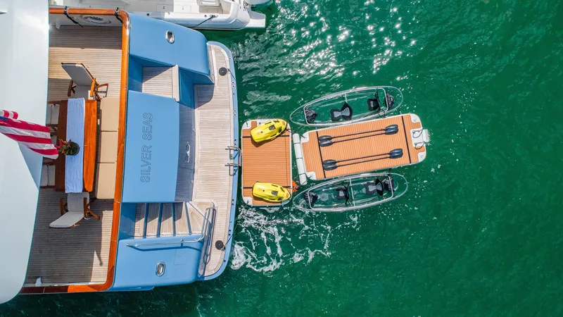 Slide: The Image of Aerial view of 1998 Burger Raised Pilothouse yacht with water toys in turquoise sea. - 8