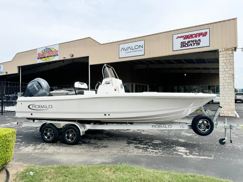 Slide: The Image of 2024 Robalo 226 Cayman boat on trailer outside dealership. - 21