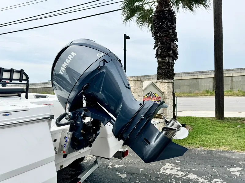 Slide: The Image of 2024 Robalo 226 Cayman with Yamaha outboard motor, parked near palm tree. - 24