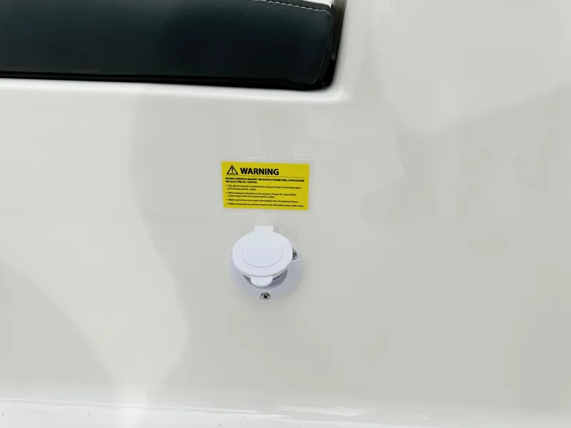 Slide: The Image of 2024 Robalo 226 Cayman boat detail with warning label and plug. - 29