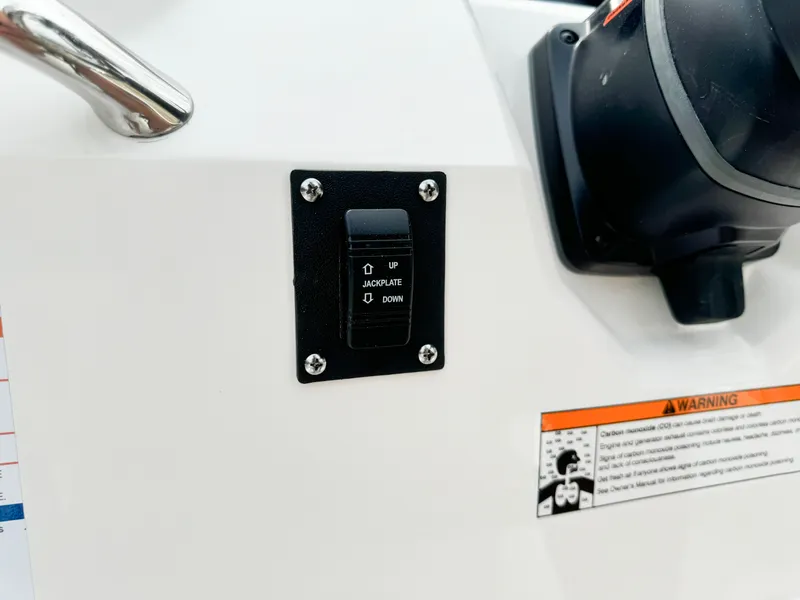 Slide: The Image of 2024 Robalo 226 Cayman trim tab switch and warning label on control panel. - 45