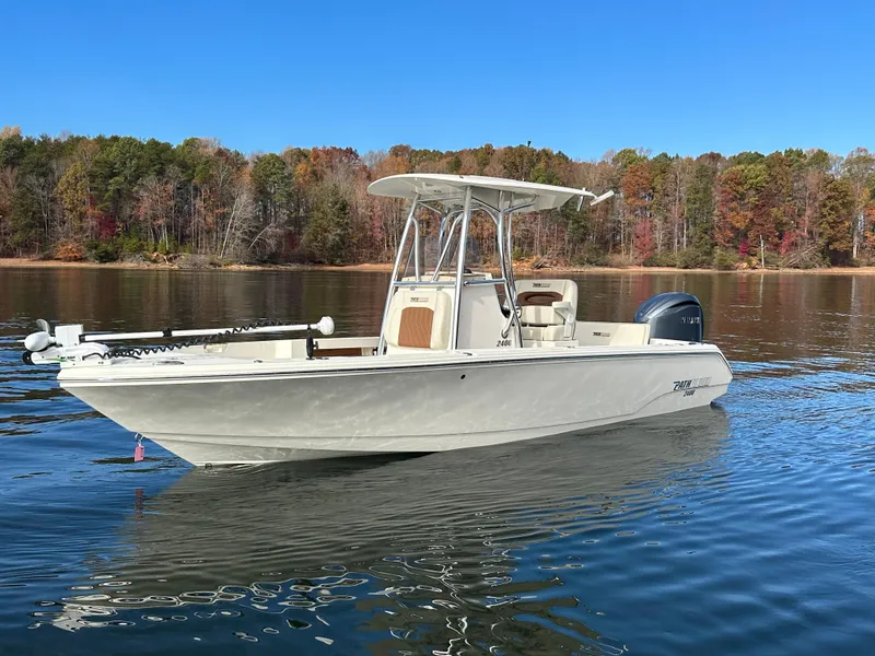 The Image of 2024 Pathfinder 2400 TRS boat on a calm lake with autumn trees in the background. - 0
