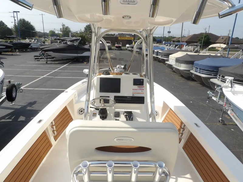 Slide: The Image of 2024 Pathfinder 2400 TRS boat interior with steering console and seating in a marina. - 4