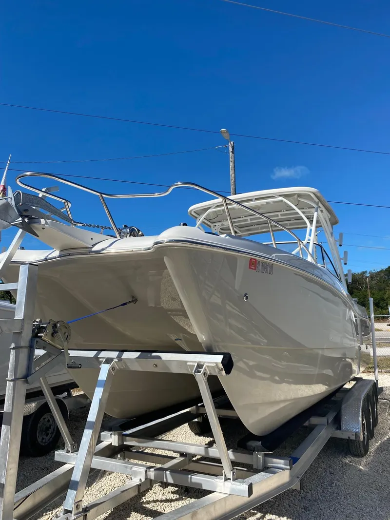 Slide: The Image of 2018 World Cat 255 DC boat on trailer under clear blue sky. - 11