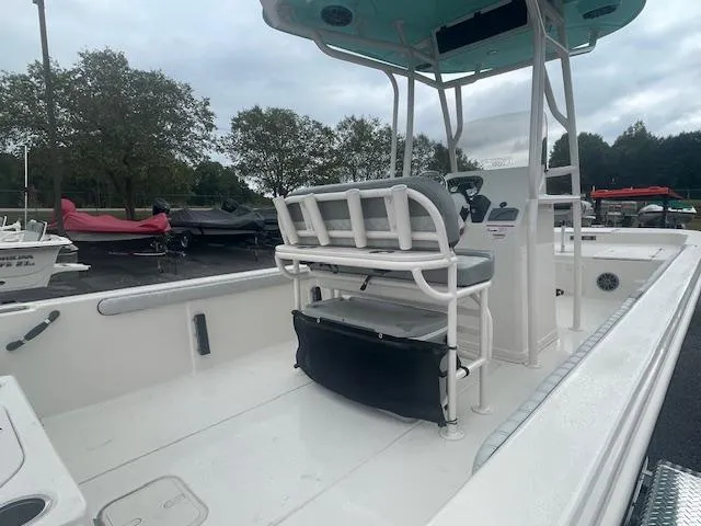 Slide: The Image of 2025 Carolina Skiff 23LS boat interior with seating and console, parked outdoors. - 11