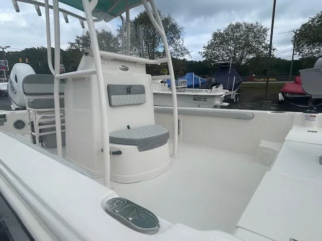 Slide: The Image of 2025 Carolina Skiff 23LS boat interior with seating and console, parked outdoors. - 6