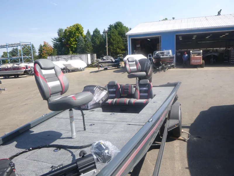 Slide: The Image of 2024 Ranger RT188C fishing boat with seating, parked outside a blue warehouse. - 17