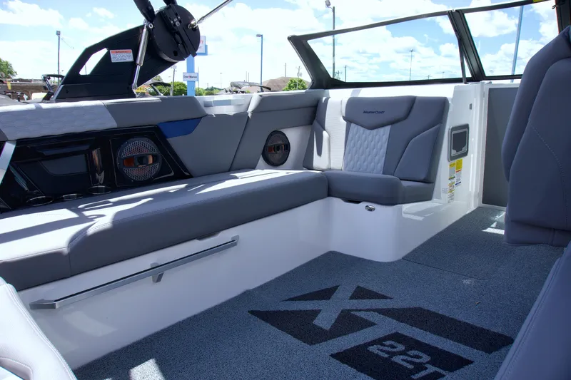 Slide: The Image of 2024 MasterCraft XT22T interior with gray seating and logo on floor. - 10