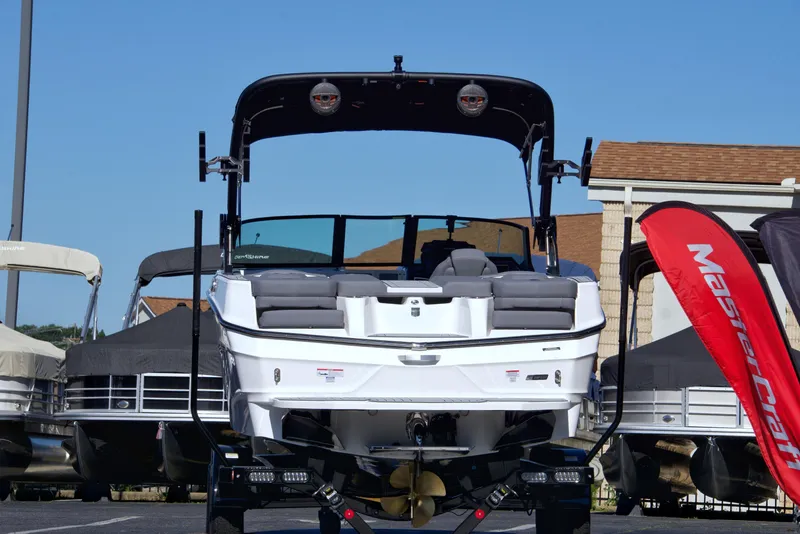 Slide: The Image of 2024 MasterCraft XT22T boat displayed outdoors with red flag and other boats. - 3