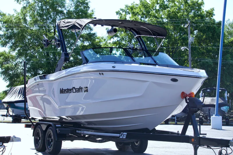 Slide: The Image of 2024 MasterCraft XT22T boat on trailer, parked outdoors. - 6