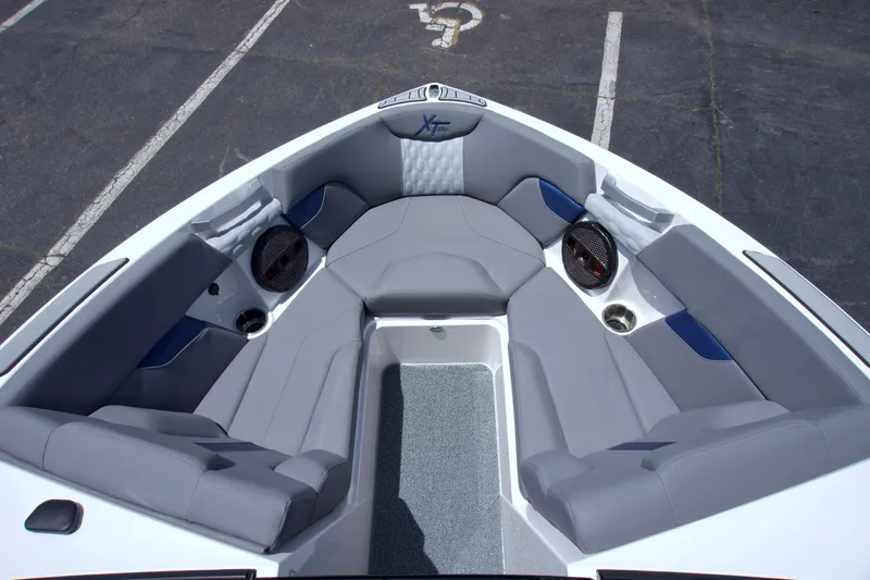 Slide: The Image of 2024 MasterCraft XT22T boat interior with gray seating and built-in speakers. - 8