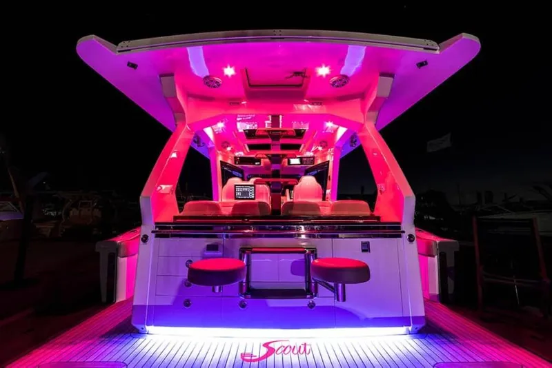 Slide: The Image of 2025 Scout 530 LXF boat with vibrant pink interior lighting at night. - 21