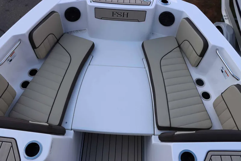 Slide: The Image of 2025 Yamaha Boats 222 FSH Sport E interior with beige seating and cup holders. - 8