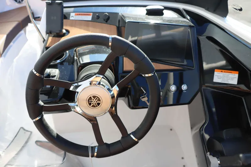 Slide: The Image of 2025 Yamaha Boats 222S steering wheel and dashboard close-up. - 12