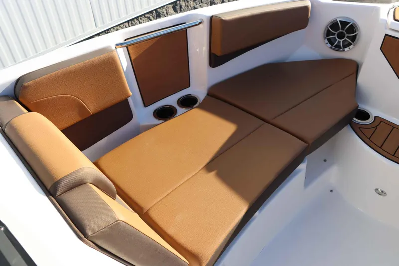Slide: The Image of 2025 Yamaha Boats 222S interior with brown cushioned seating and speaker. - 17