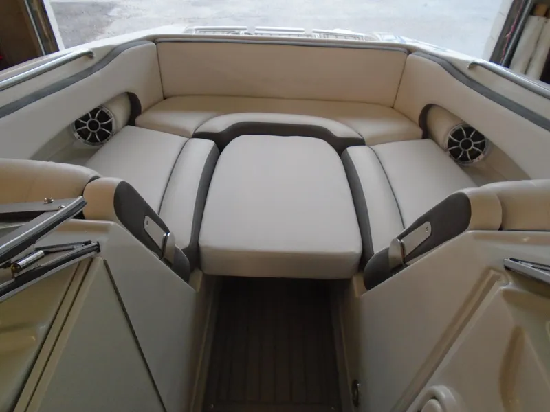 Slide: The Image of 2024 Crownline E 235 Surf boat interior with cushioned seating and built-in speakers. - 13