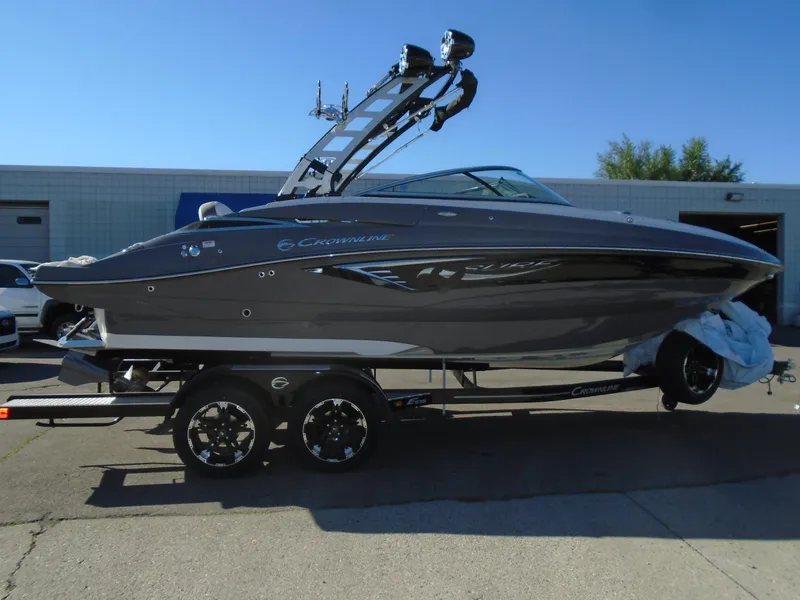 Slide: The Image of 2024 Crownline E 235 Surf boat on trailer, sleek design, gray exterior. - 3