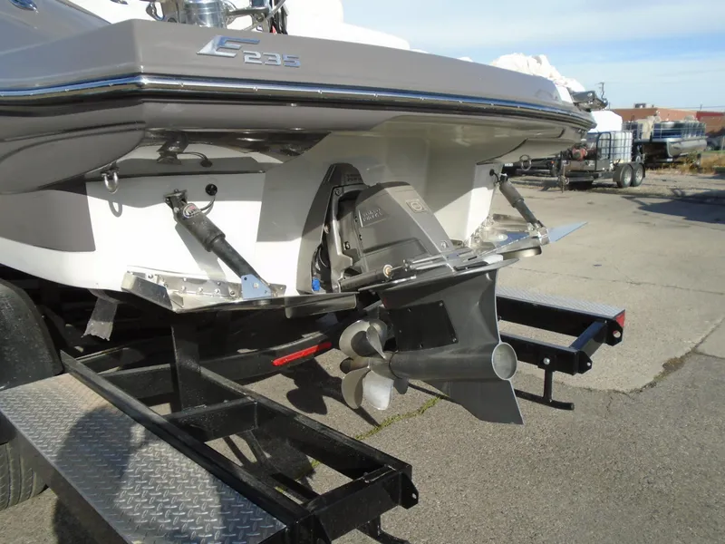 Slide: The Image of 2024 Crownline E 235 Surf boat on trailer, showcasing rear view and propeller. - 5
