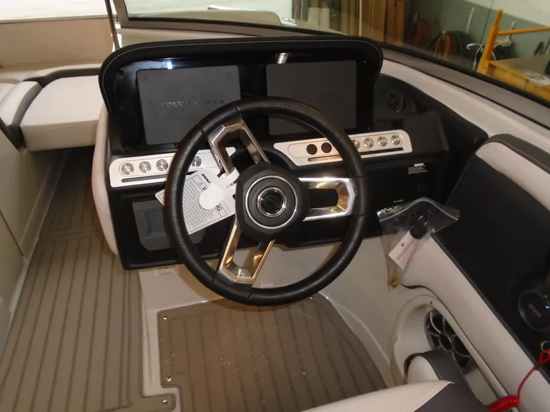 Slide: The Image of 2024 Crownline E 235 Surf boat dashboard with steering wheel and controls. - 7