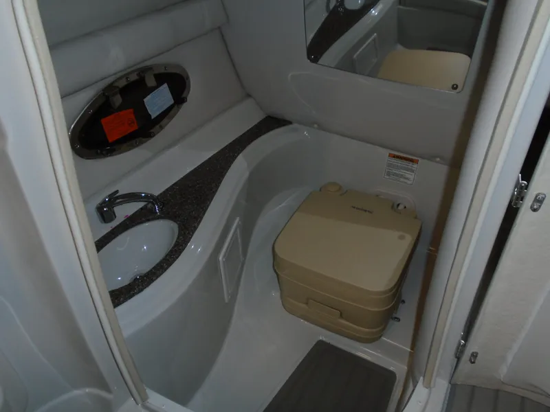 Slide: The Image of 2024 Crownline E 235 Surf boat bathroom with sink and portable toilet. - 8