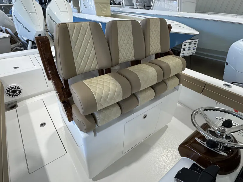 Slide: The Image of 2025 Valhalla Boatworks V-29 interior with beige quilted seats and steering wheel. - 8