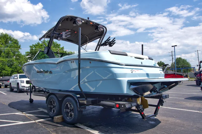 Slide: The Image of 2024 MasterCraft NXT23 boat on trailer in parking lot, sunny day. - 10