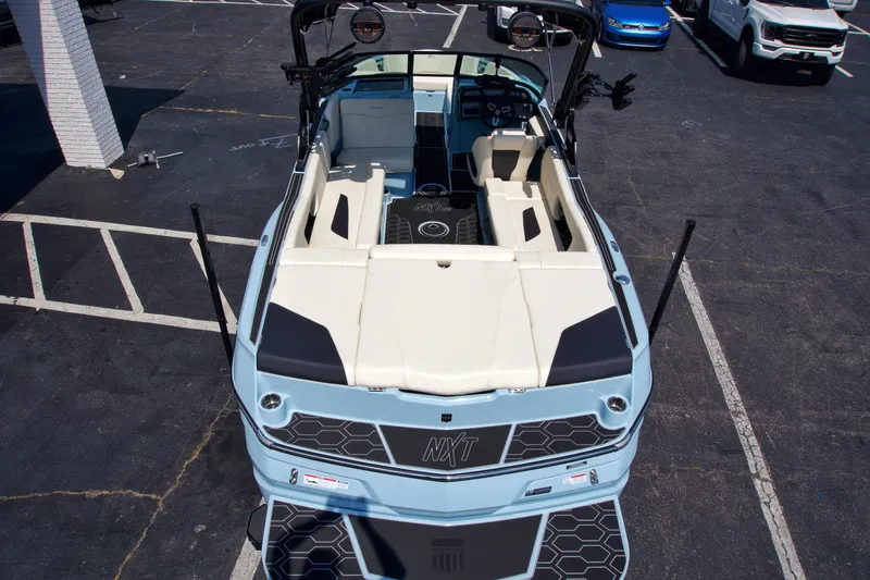 Slide: The Image of 2024 MasterCraft NXT23 boat, aerial view, parked on asphalt. - 12